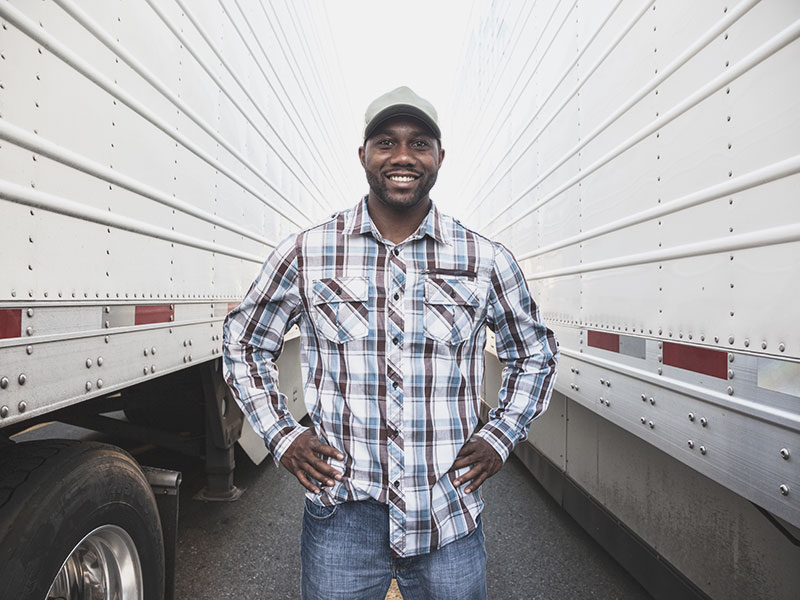 truck driver standing between two semis